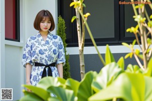 A naked asian woman sitting on a chair in a blue shirt.