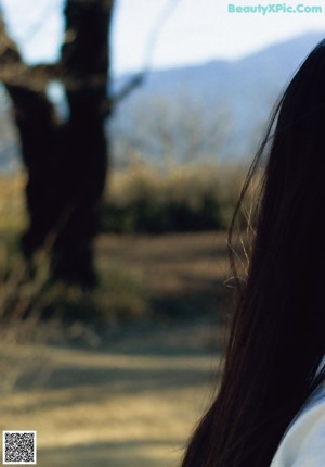 A woman with long black hair and a gray scarf.