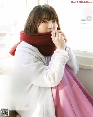 A woman standing in front of a bush in a magazine.