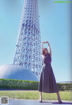A woman in a black and white striped dress posing for a picture.