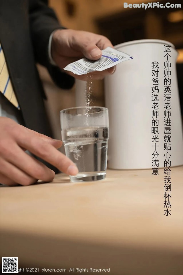 A man in a suit is pouring water into a glass.