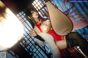 A woman in a red and gold outfit holding a musical instrument.