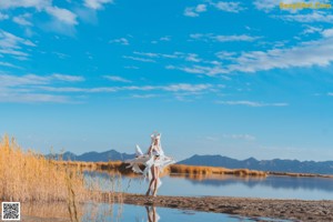 A woman in a blue bikini standing in a field.