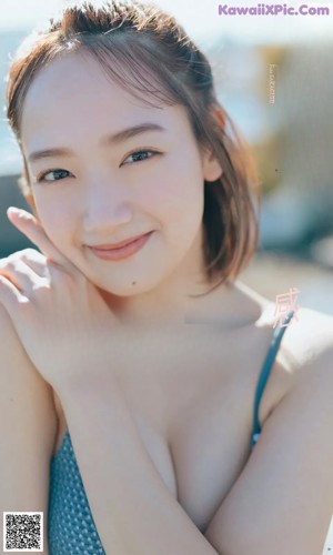 A woman in a gray sweater is posing for a magazine.