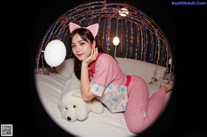 A woman in a pink cat costume sitting on the floor.