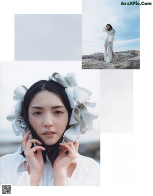 A woman in a white dress standing on top of a hill.