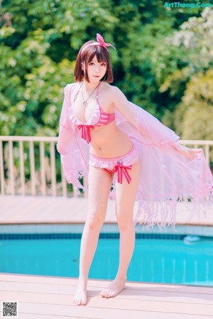 A woman in a pink bikini sitting on a table.