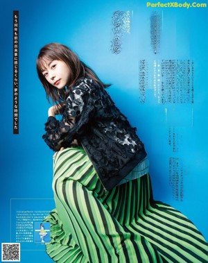 A woman in a black dress is posing for a magazine.