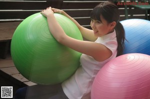 A woman in a pink tank top and blue shorts posing for a picture.