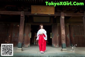 A woman in a maid outfit sitting on the floor.