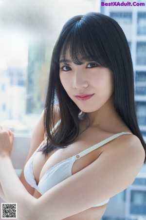 A woman in a white shirt is posing for a picture.