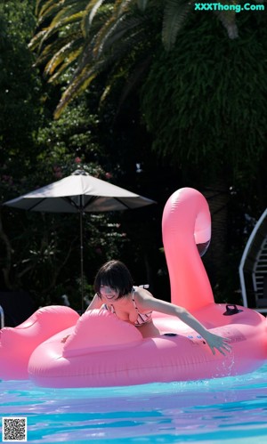 A woman in a striped bikini sitting on a lawn chair.