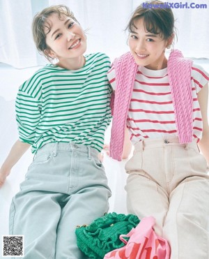 A couple of women laying on top of a bed.
