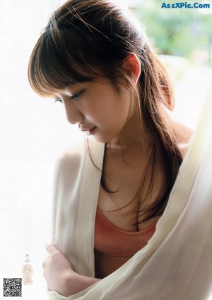A woman in a blue dress sitting on a brick walkway.