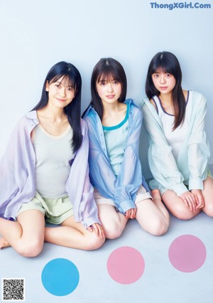 A group of young women holding balloons in front of a blue sky.