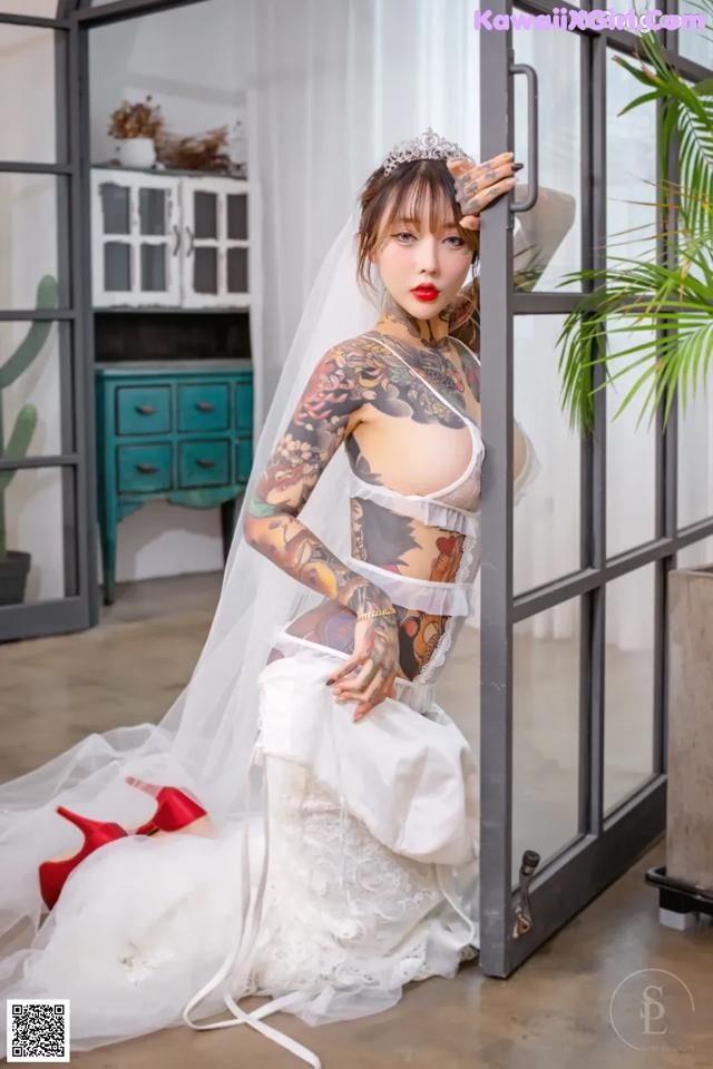 A woman in a wedding dress with tattoos on her body.