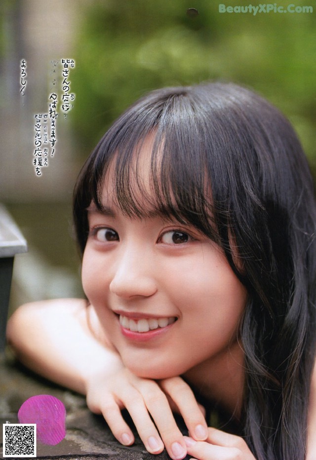 A young woman with long black hair smiling at the camera.