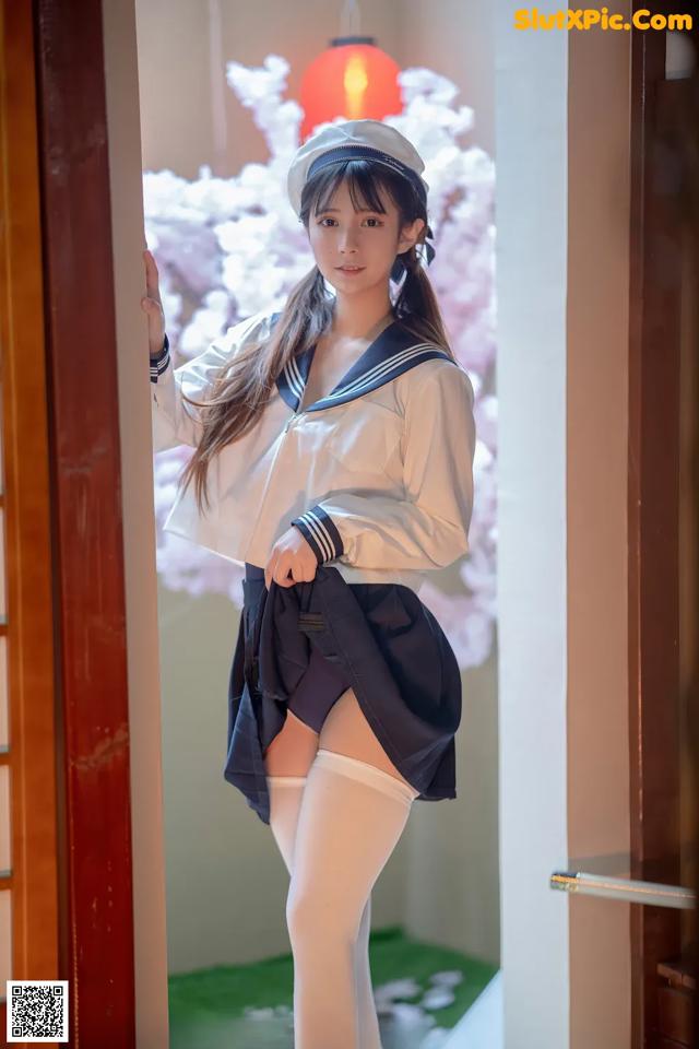 A woman in a sailor outfit posing for a picture.