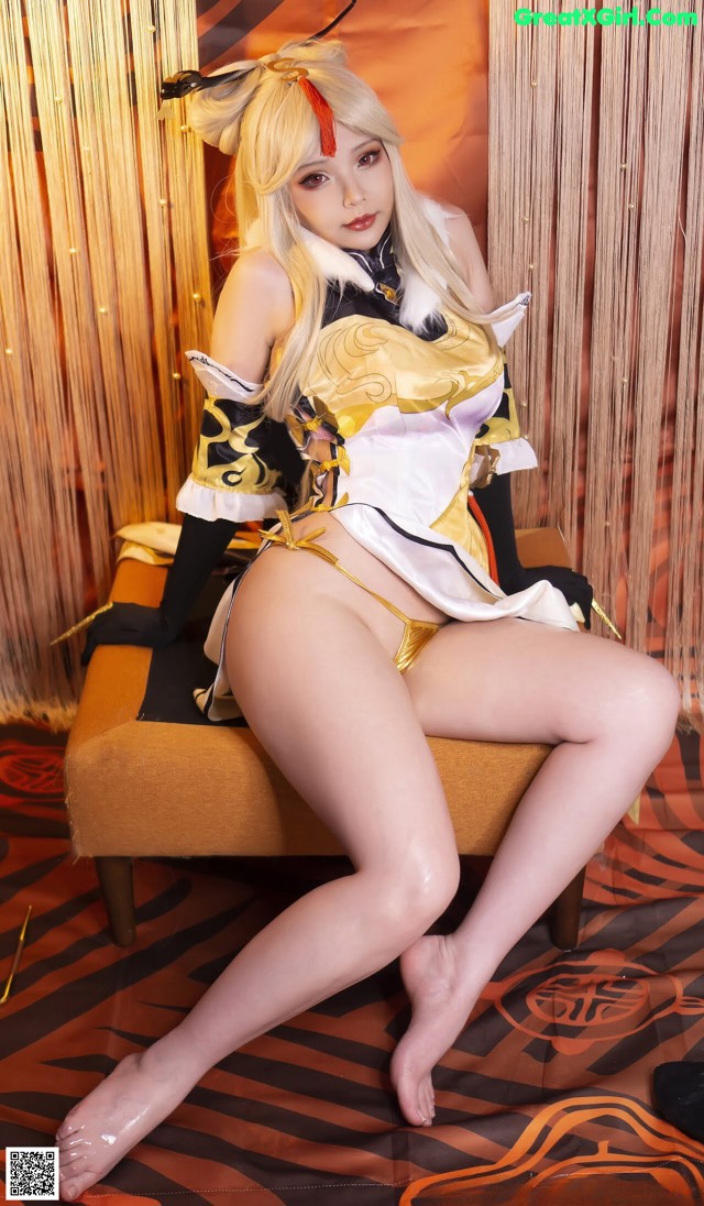 A woman in a yellow and black outfit sitting on a chair.