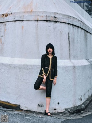 A woman wearing a black top and a white skirt.